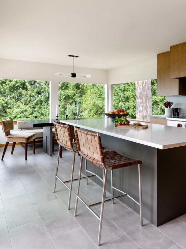 Inspiration for a mid-sized modern kitchen in Seattle with flat-panel cabinets, brown cabinets, quartz benchtops, grey splashback, engineered quartz splashback, stainless steel appliances, porcelain floors, with island, grey floor and white benchtop.