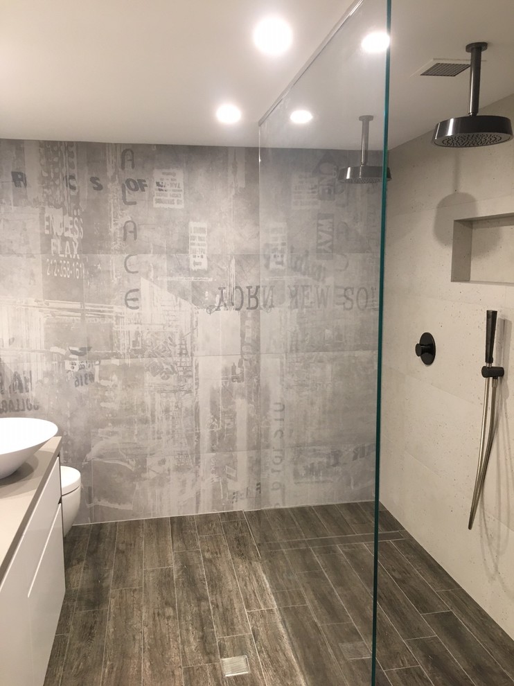Inspiration for a large industrial master bathroom in Sydney with flat-panel cabinets, white cabinets, an open shower, a one-piece toilet, beige tile, stone slab, beige walls, porcelain floors, a vessel sink, engineered quartz benchtops, brown floor, beige benchtops, a niche and a double vanity.