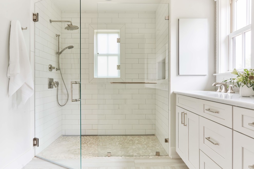 Rockville - Inspiration for a large country master white tile and mosaic tile light wood floor and beige floor alcove shower remodel in Richmond with shaker cabinets, white cabinets, a two-piece toilet, white walls, an undermount sink, quartzite countertops, a hinged shower door and white countertops
