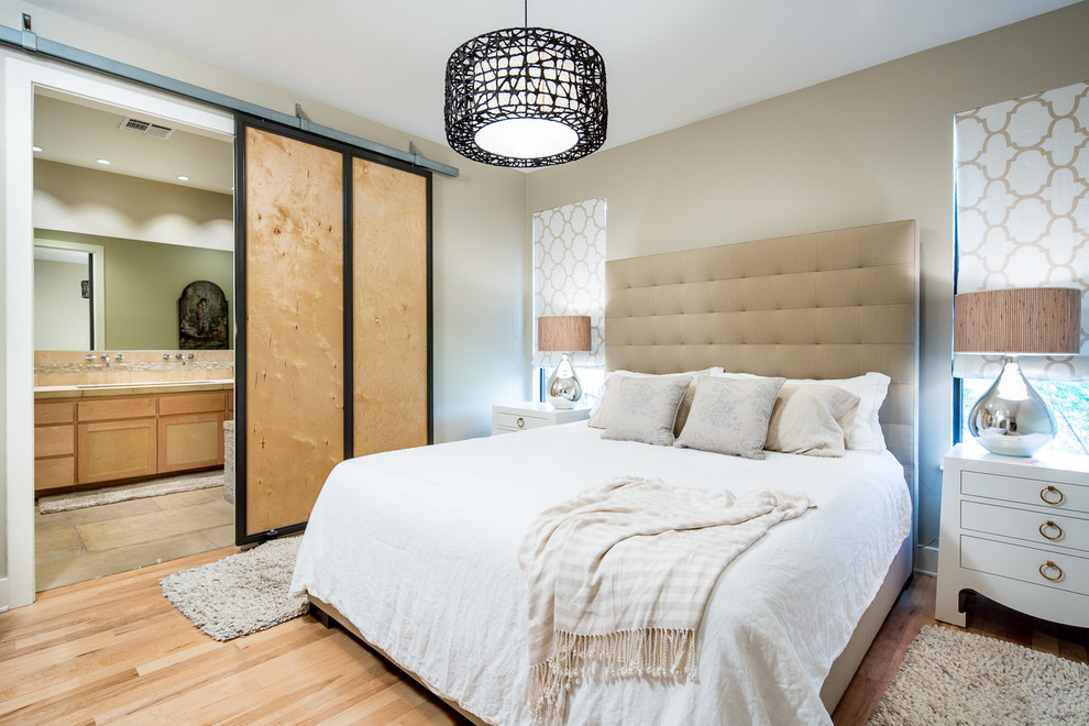 Design ideas for a transitional master bedroom in Austin with beige walls and light hardwood floors.