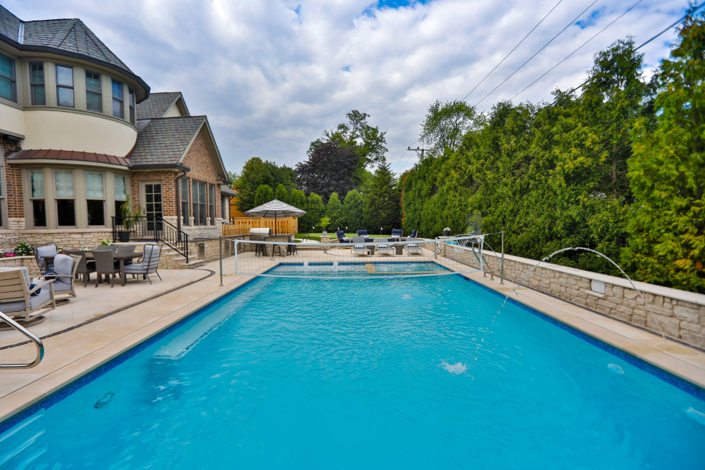 Пример оригинального дизайна: спортивный, прямоугольный бассейн среднего размера на заднем дворе в классическом стиле с перегородкой для приватности и покрытием из каменной брусчатки