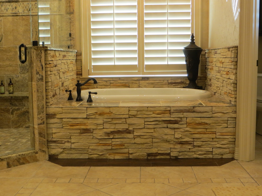 Drop-in bathtub - large rustic master brown tile and stone tile ceramic tile drop-in bathtub idea in Dallas with an undermount sink, raised-panel cabinets, dark wood cabinets, granite countertops, a two-piece toilet and beige walls