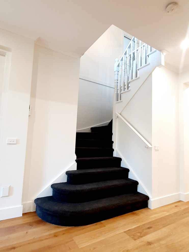 Photo of a contemporary carpeted u-shaped staircase in Melbourne with carpet risers.
