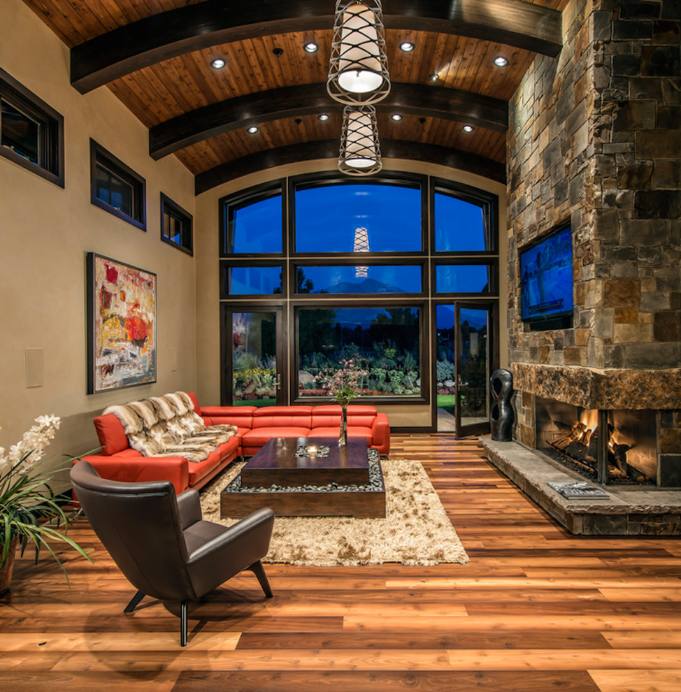 Photo of a large contemporary formal open concept living room in Denver with beige walls, dark hardwood floors, a two-sided fireplace, a stone fireplace surround and a wall-mounted tv.