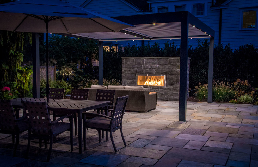 Photo of a mid-sized contemporary backyard patio in New York with natural stone pavers.