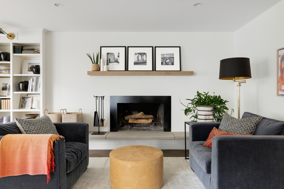 This is an example of a large transitional family room in Minneapolis with white walls, medium hardwood floors, a standard fireplace, a metal fireplace surround and brown floor.