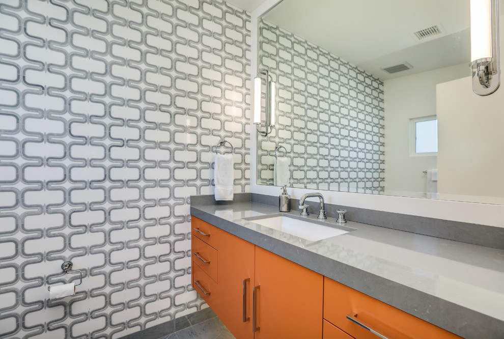 Inspiration for a mid-sized midcentury bathroom in San Diego with flat-panel cabinets, orange cabinets, an alcove shower, a one-piece toilet, multi-coloured tile, marble, multi-coloured walls, marble floors, an undermount sink, engineered quartz benchtops, grey floor, a hinged shower door and grey benchtops.