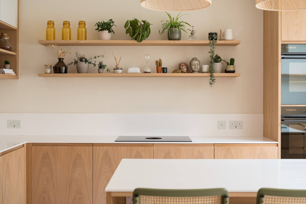 Photo of a mid-sized scandinavian kitchen in London with medium wood cabinets, with island and white benchtop.