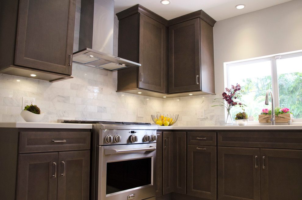 Example of a mid-sized transitional u-shaped enclosed kitchen design in Miami with an undermount sink, flat-panel cabinets, gray cabinets, quartz countertops, white backsplash, subway tile backsplash and stainless steel appliances