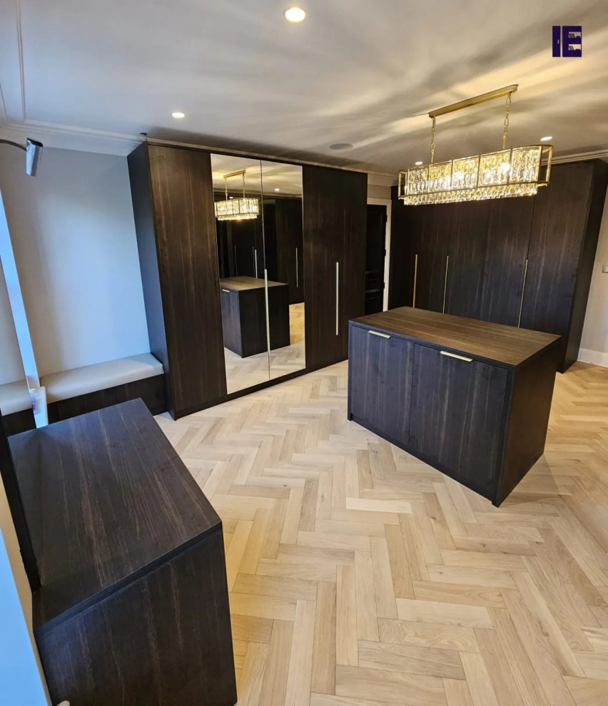 Idéer för ett stort modernt walk-in-closet, med luckor med glaspanel, skåp i mörkt trä och plywoodgolv