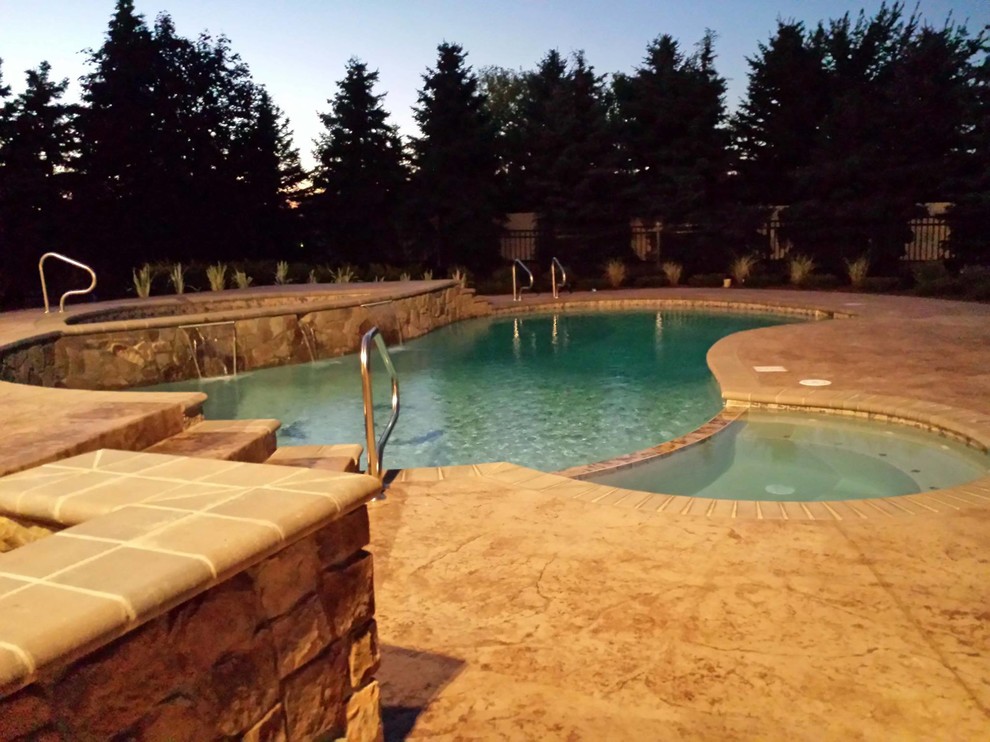 Inspiration for a mid-sized transitional backyard stamped concrete and custom-shaped lap hot tub remodel in Detroit