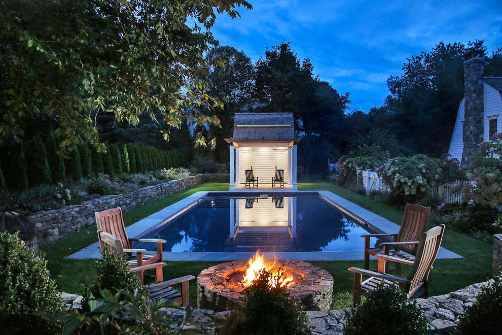 Country rectangular pool in New York with a pool house.