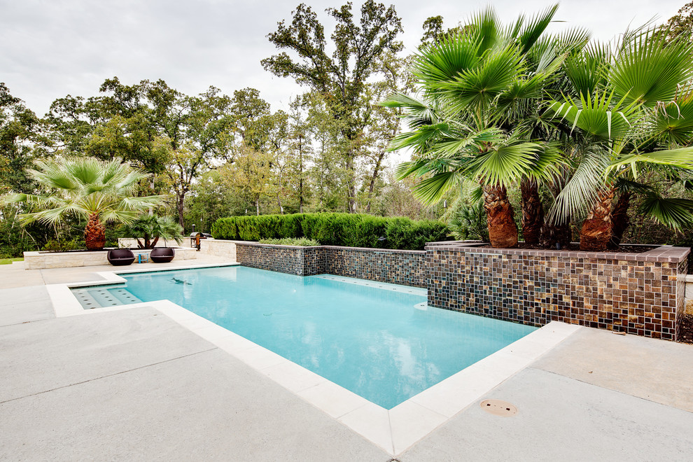 Photo of a mid-sized modern backyard rectangular pool in Austin with concrete slab.