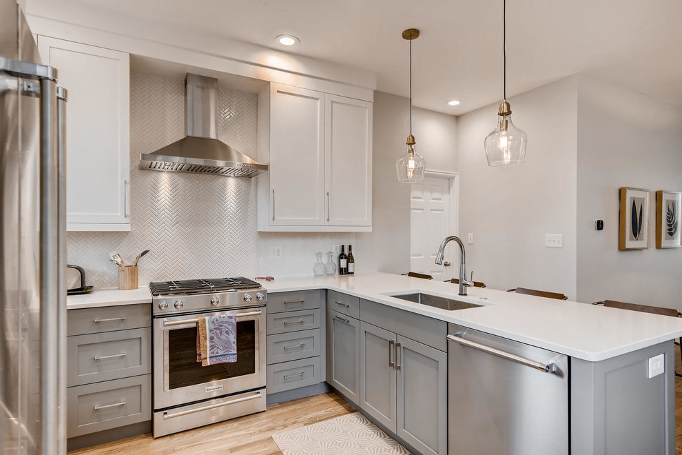 Small transitional u-shaped light wood floor and brown floor eat-in kitchen photo in Denver with an undermount sink, shaker cabinets, white cabinets, granite countertops, white backsplash, ceramic backsplash, stainless steel appliances, a peninsula and white countertops
