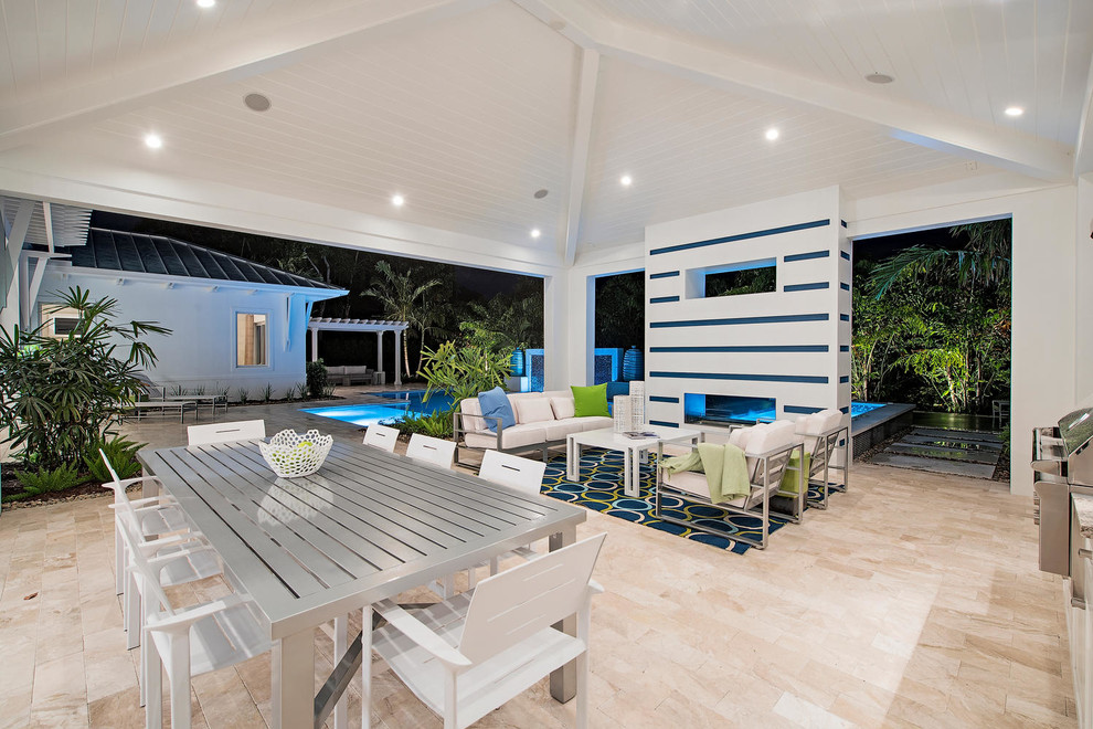 Inspiration for a large transitional backyard patio in Miami with an outdoor kitchen, tile and a roof extension.