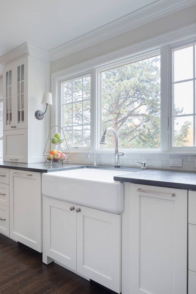 Eat-in kitchen - large transitional u-shaped light wood floor and brown floor eat-in kitchen idea in Denver with a farmhouse sink, shaker cabinets, white cabinets, quartz countertops, white backsplash, marble backsplash, paneled appliances and two islands
