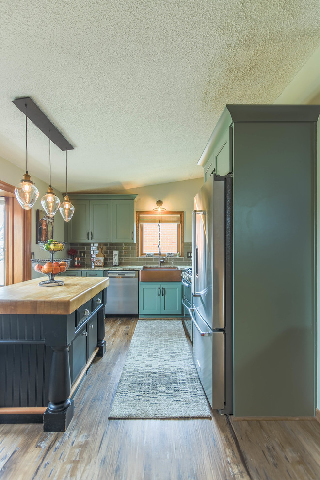 Inspiration for a small transitional l-shaped eat-in kitchen in Detroit with a farmhouse sink, shaker cabinets, green cabinets, quartz benchtops, grey splashback, glass tile splashback, stainless steel appliances, dark hardwood floors, with island, brown floor and beige benchtop.