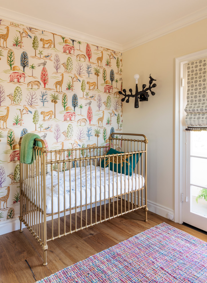 Immagine di una cameretta per neonati eclettica con pareti beige e carta da parati