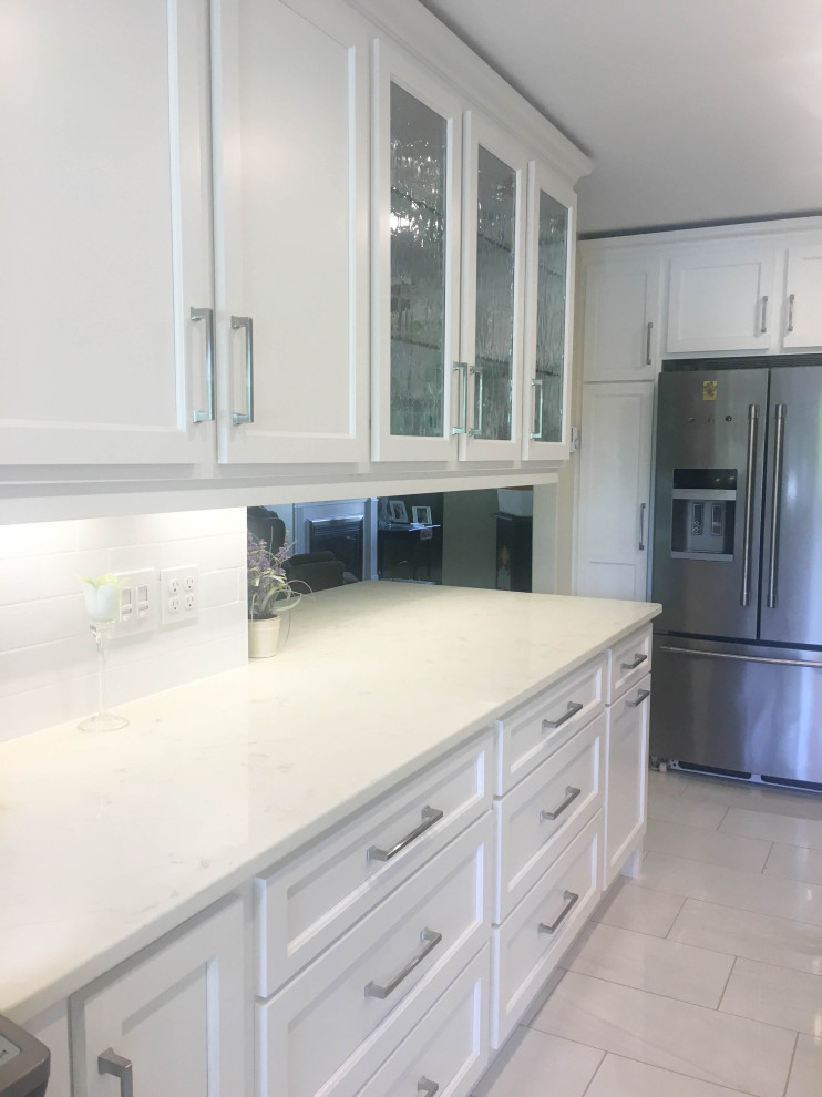 Inspiration for a mid-sized transitional u-shaped porcelain tile and gray floor eat-in kitchen remodel with an undermount sink, shaker cabinets, white cabinets, quartz countertops, white backsplash, subway tile backsplash, stainless steel appliances, a peninsula and beige countertops