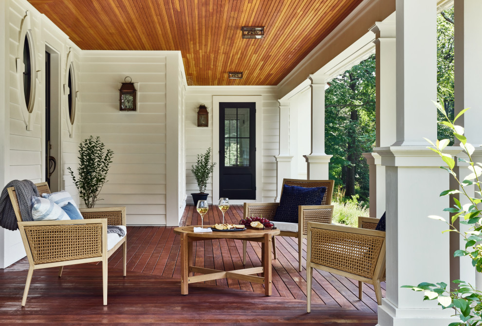 Exemple d'un porche d'entrée de maison avant nature de taille moyenne avec des colonnes et un garde-corps en bois.