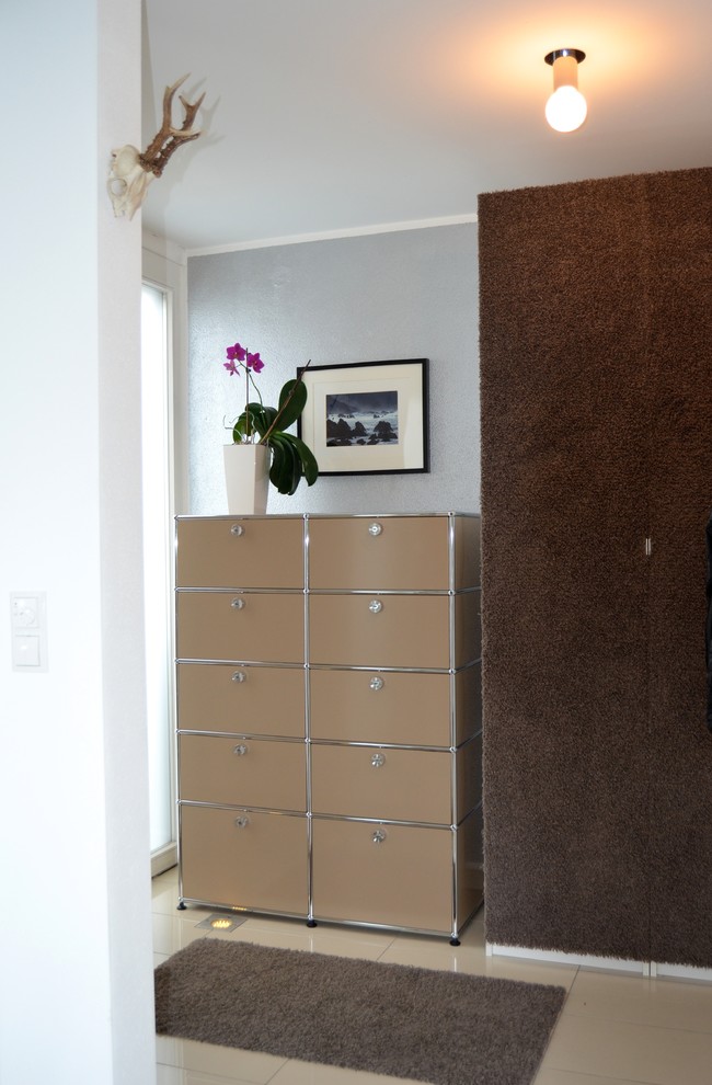 This is an example of a small contemporary mudroom in Munich with metallic walls and granite floors.