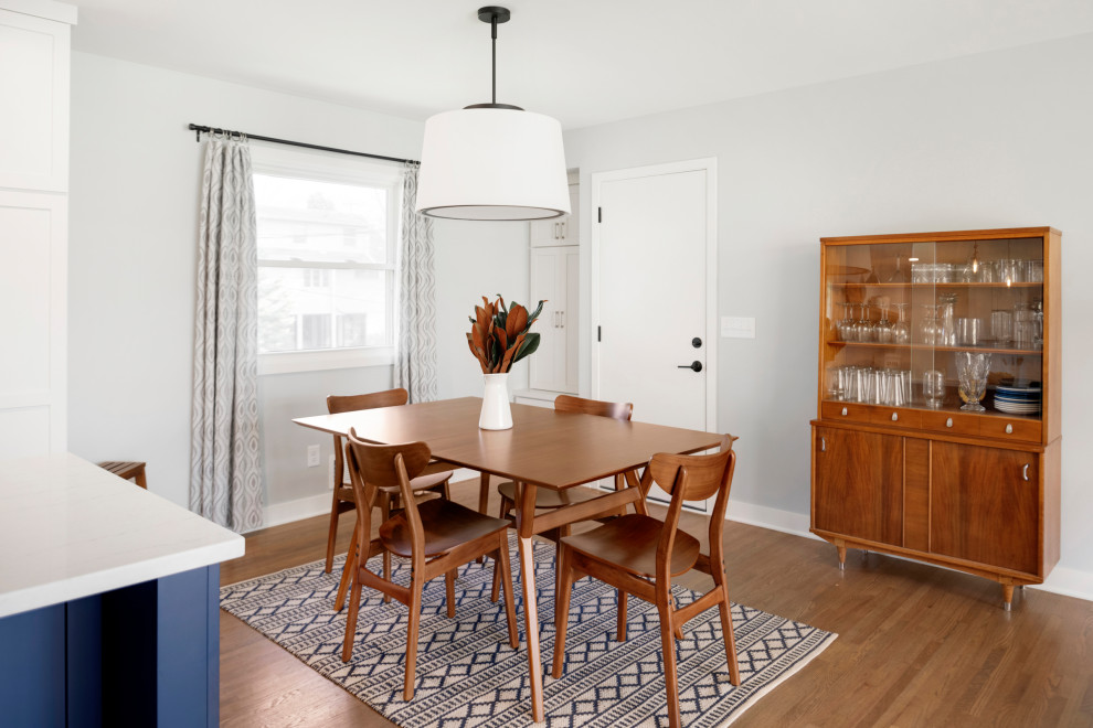 Esempio di una grande sala da pranzo aperta verso la cucina minimalista con pavimento in legno massello medio e pavimento marrone