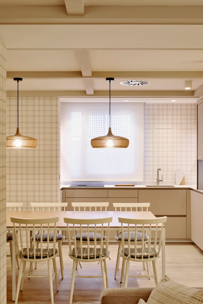 Foto de comedor de cocina tradicional renovado grande sin chimenea con paredes beige, suelo laminado, casetón y papel pintado