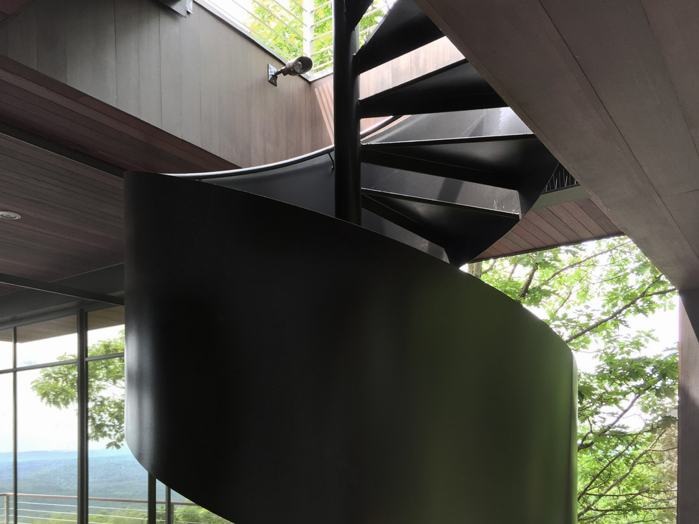 This is an example of a mid-sized midcentury metal spiral staircase in New York with metal risers.