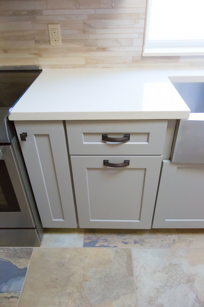 Mid-sized transitional u-shaped porcelain tile kitchen photo in Phoenix with a farmhouse sink, shaker cabinets, gray cabinets, quartz countertops, gray backsplash, porcelain backsplash, stainless steel appliances and a peninsula
