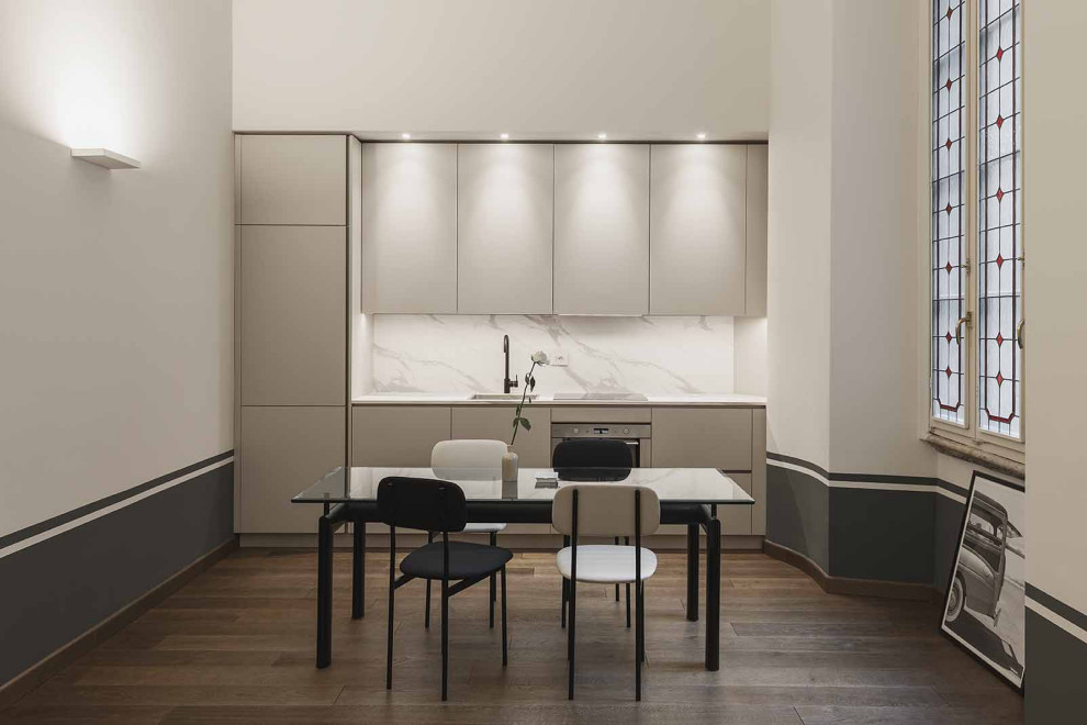 Design ideas for a mid-sized contemporary single-wall open plan kitchen in Milan with a drop-in sink, flat-panel cabinets, beige cabinets, marble benchtops, multi-coloured splashback, marble splashback, stainless steel appliances, dark hardwood floors, no island and multi-coloured benchtop.