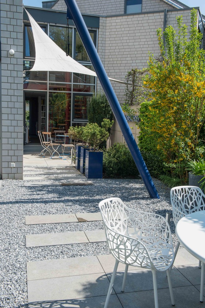 Geometrischer, Kleiner, Halbschattiger Moderner Gartenweg im Frühling, hinter dem Haus mit Natursteinplatten in Sonstige