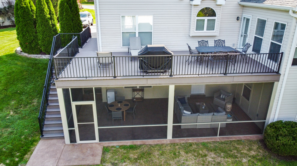 Modelo de terraza de tamaño medio en patio trasero con privacidad y barandilla de metal