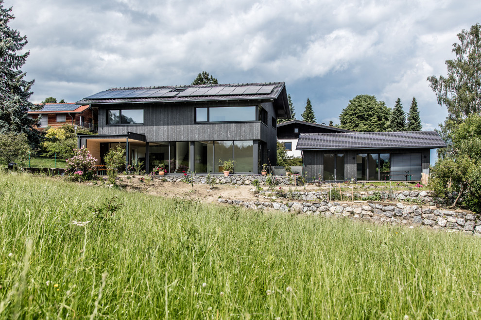 Zweistöckiges Modernes Haus mit grauer Fassadenfarbe, Satteldach, Ziegeldach und grauem Dach in München