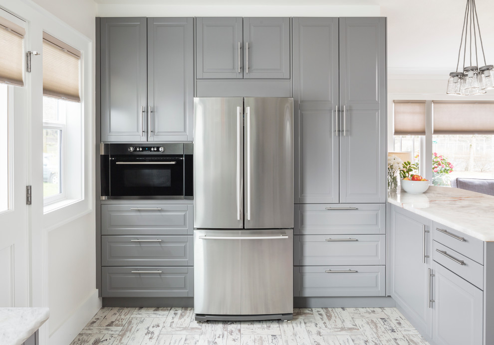 Design ideas for a mid-sized contemporary u-shaped kitchen in Seattle with a farmhouse sink, glass-front cabinets, grey cabinets, marble benchtops, white splashback, subway tile splashback and stainless steel appliances.