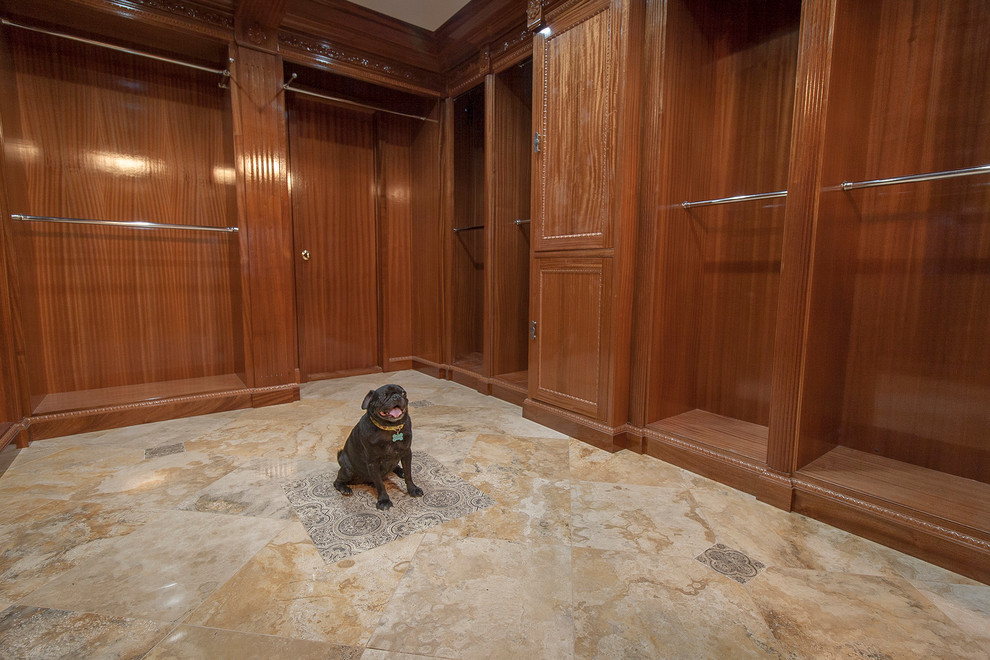 Photo of a large traditional gender-neutral walk-in wardrobe in San Diego with medium wood cabinets and travertine floors.