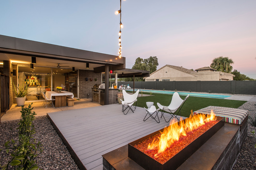 Small midcentury backyard deck in Phoenix with a fire feature and no cover.