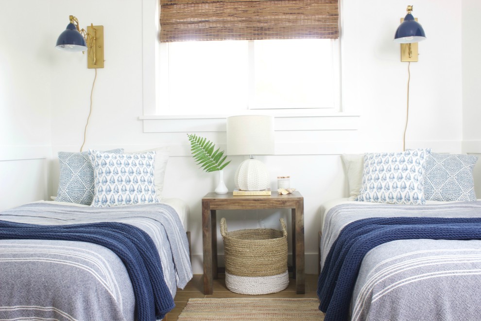 This is an example of a mid-sized beach style guest bedroom in Orlando with white walls, ceramic floors and brown floor.