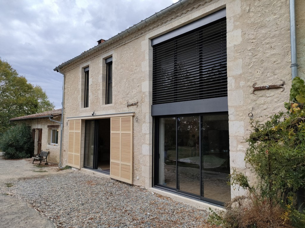 Inspiration for a large contemporary three-storey house exterior in Toulouse with stone veneer, a gable roof, a tile roof and a red roof.