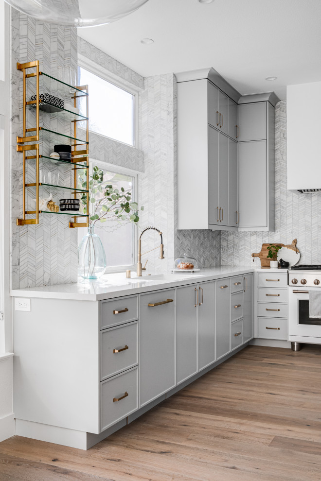 Design ideas for a small contemporary u-shaped separate kitchen in Los Angeles with an undermount sink, shaker cabinets, grey cabinets, quartz benchtops, white splashback, marble splashback, white appliances, medium hardwood floors, no island, brown floor and white benchtop.