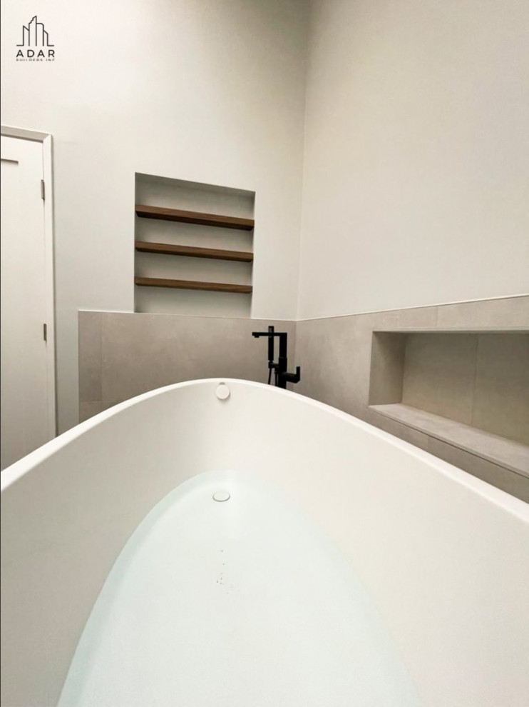 Exempel på ett stort modernt grå grått en-suite badrum, med släta luckor, skåp i mellenmörkt trä, ett fristående badkar, en dusch i en alkov, vita väggar, klinkergolv i keramik, granitbänkskiva, svart golv och dusch med gångjärnsdörr