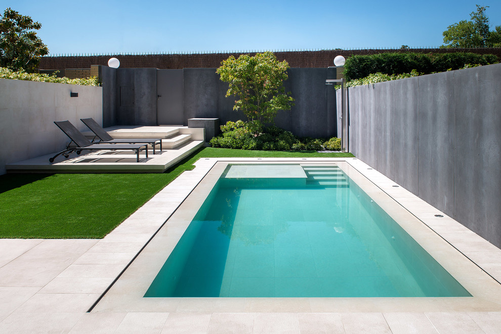 Mid-sized contemporary rectangular pool in Madrid with tile.