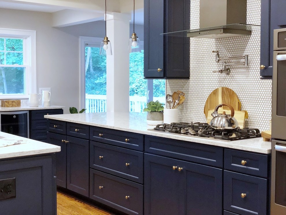 Eat-in kitchen - transitional medium tone wood floor eat-in kitchen idea in Cincinnati with flat-panel cabinets, blue cabinets, quartz countertops, white backsplash, porcelain backsplash, an island and white countertops