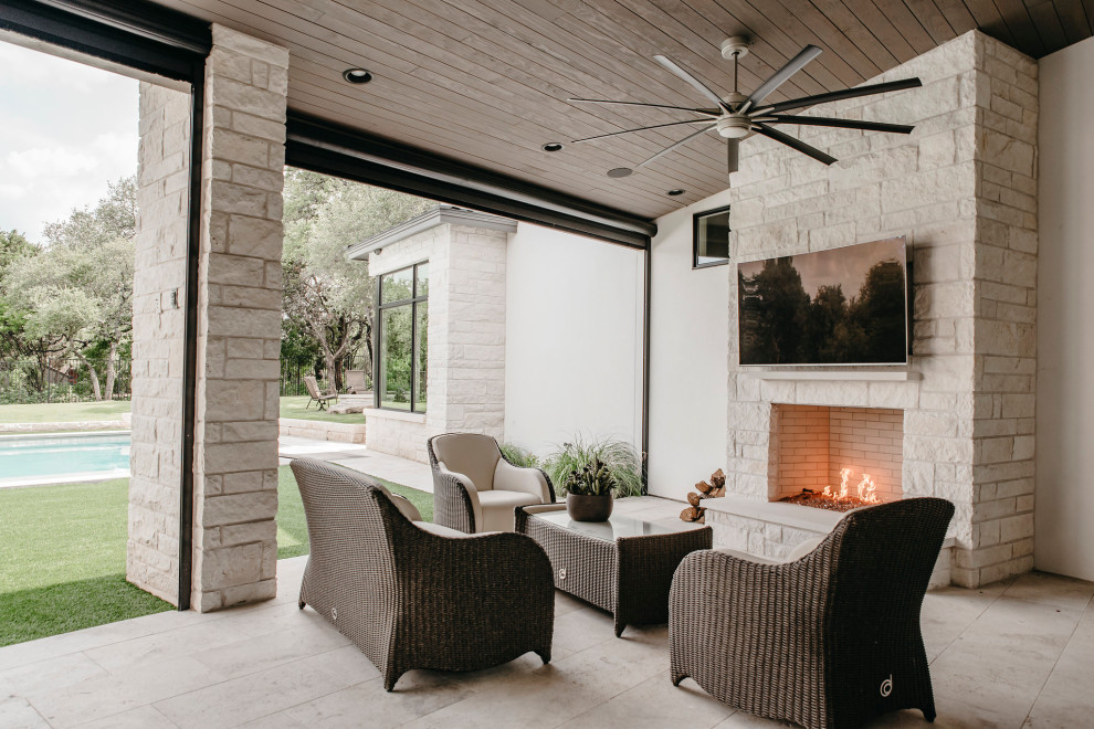 Large contemporary backyard patio in Austin with with fireplace and a roof extension.