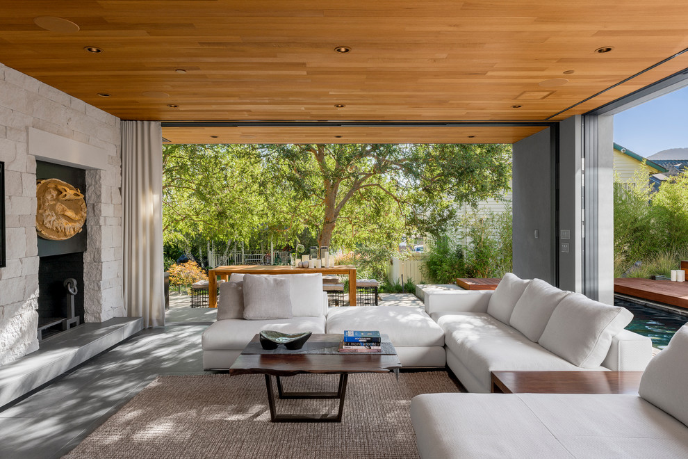 Photo of a contemporary patio in Los Angeles with a roof extension and with fireplace.