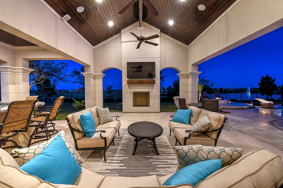 Photo of a large modern backyard patio in Houston with with fireplace, tile and a roof extension.