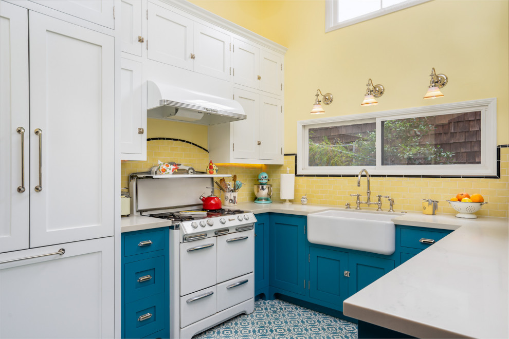 Inspiration for a small country u-shaped eat-in kitchen in Los Angeles with a farmhouse sink, beaded inset cabinets, blue cabinets, quartz benchtops, yellow splashback, subway tile splashback, white appliances, cement tiles, blue floor and white benchtop.
