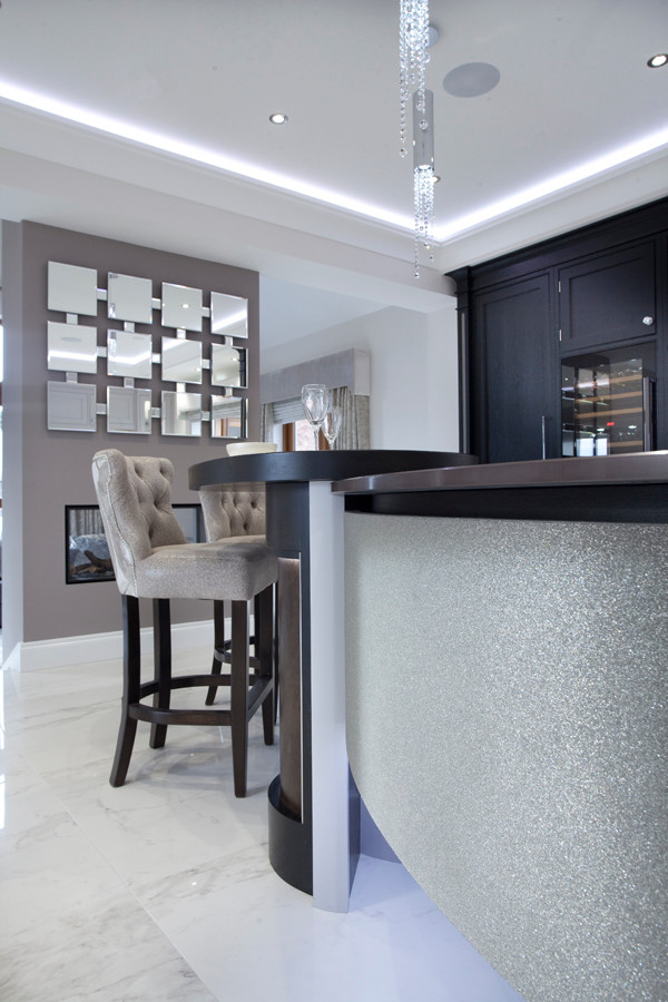 Mid-sized contemporary l-shaped home bar in Belfast with an integrated sink, beaded inset cabinets, grey cabinets, quartzite benchtops, white splashback, stone slab splashback and marble floors.