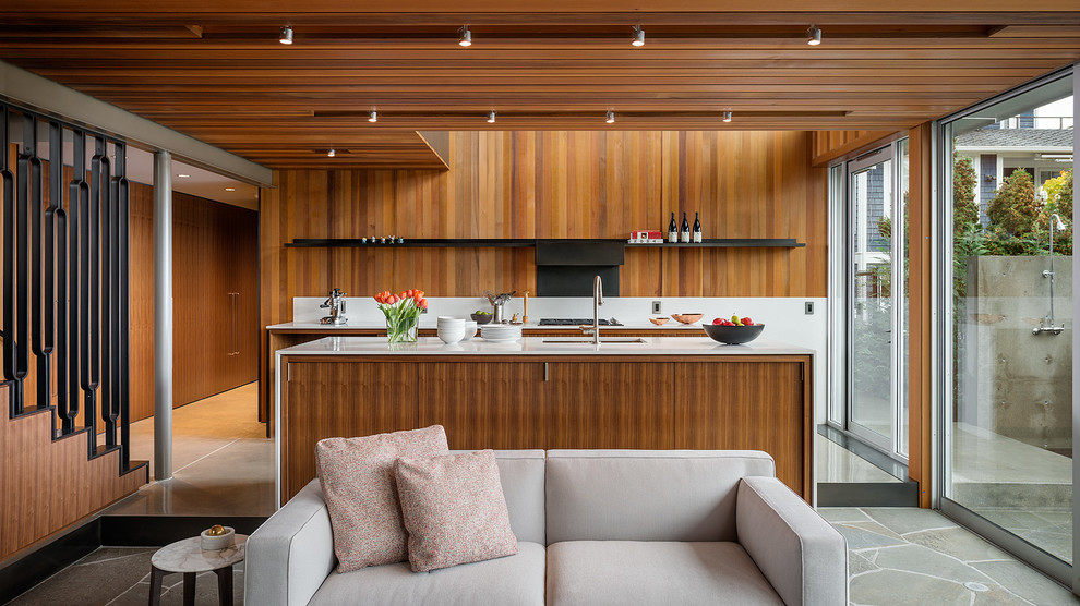 Photo of a modern galley open plan kitchen in Seattle with flat-panel cabinets, medium wood cabinets, with island, quartz benchtops, white splashback and stainless steel appliances.