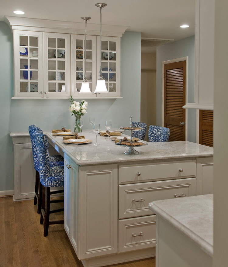 Mid-sized transitional l-shaped light wood floor and brown floor eat-in kitchen photo in Baltimore with recessed-panel cabinets, white cabinets, marble countertops, a peninsula, an undermount sink, white backsplash, mosaic tile backsplash and stainless steel appliances
