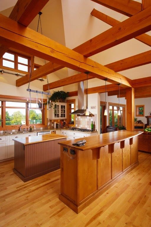 Photo of a mid-sized country u-shaped eat-in kitchen in Vancouver with a double-bowl sink, shaker cabinets, white cabinets, wood benchtops, multi-coloured splashback, ceramic splashback, stainless steel appliances, light hardwood floors and multiple islands.